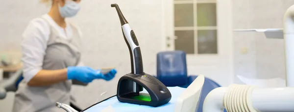 En moderne fotopolymerisationslampe til lette fyldninger på tandkontoret på en sløret baggrund - Stock-foto