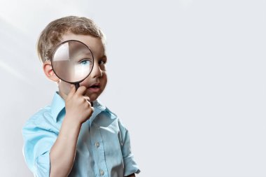 büyük bir büyüteç içine bakarak hafif bir t-shirt çocuk