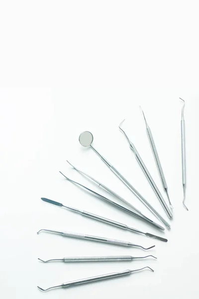 Um várias ferramentas dentárias estabelecidas flatlay em um fundo leve — Fotografia de Stock