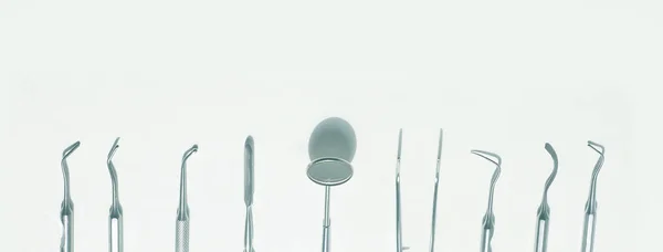 Divers outils dentaires disposés flatlay sur un fond clair — Photo