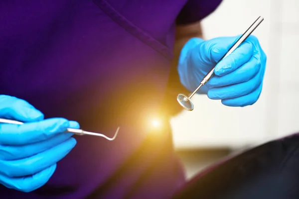 På tandklinikkens kontor. Lægen har værktøjer til undersøgelse af tænder i sterile handsker . - Stock-foto