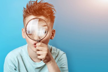 büyük bir büyüteç içine bakarak hafif bir t-shirt çocuk