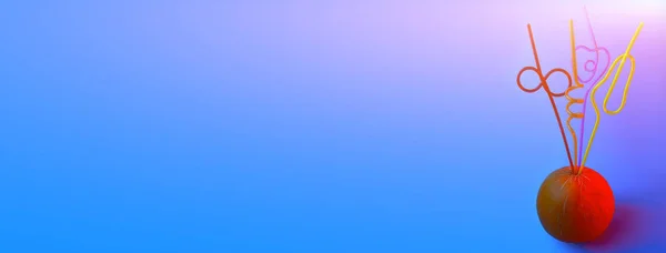 Яскраві кольорові коктейльні трубки, застрягли в дині на синьому фоні — стокове фото