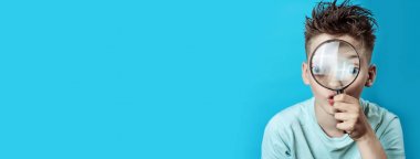 büyük bir büyüteç içine bakarak hafif bir t-shirt çocuk