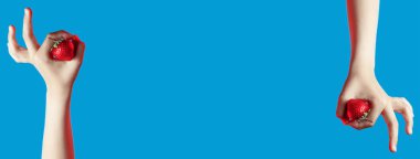 mavi arka plan üzerinde elinde parlak sulu çilek kolaj. parmaklar bir işaret gösterir tamam