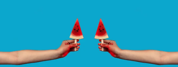 Dos manos sosteniendo un trozo de sandía en un palo como helado sobre fondo azul —  Fotos de Stock