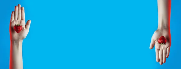 Колаж яскравої соковитої полуниці в руці на синьому фоні — стокове фото
