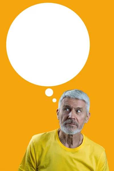 Portræt af overrasket og nysgerrig gråhåret mand med skæg på gul baggrund - Stock-foto