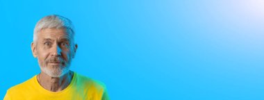 mavi bir arka plan üzerinde sakallı sürpriz ve meraklı gri saçlı adam portresi