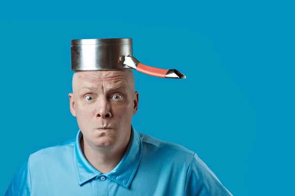Un hombre calvo y brutal con camiseta azul se puso una olla en la cabeza — Foto de Stock