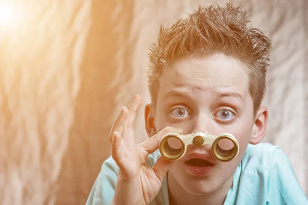 Surpreso adolescente menino emocionalmente olhando através binóculos — Fotografia de Stock