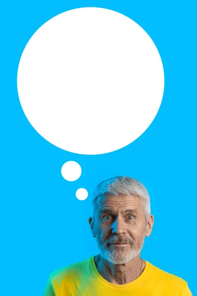 Portrait of surprised and curious gray-haired man with a beard on a blue background — Stock Photo, Image