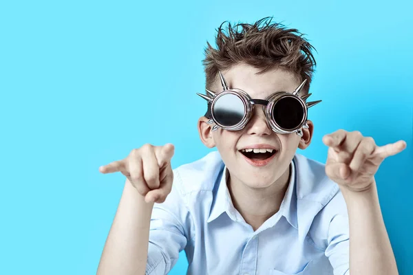 Хлопчик-рокер у блакитній сорочці та байкерських окулярах на світло-блакитному фоні — стокове фото