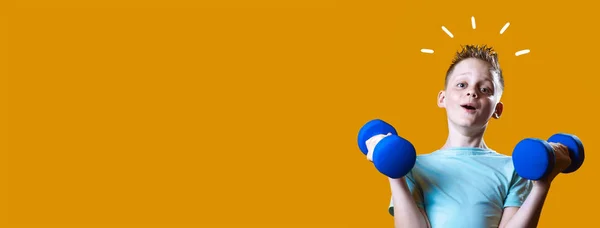 Um menino em uma camiseta brilhante com halteres em um fundo amarelo — Fotografia de Stock