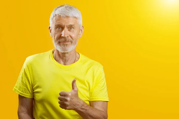 Portrait of a gray-haired man with a beard shows gesture good on blue background — Stock Photo, Image