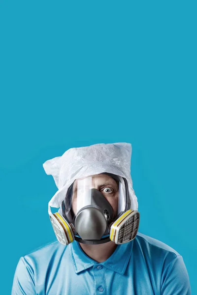 En mand i en gasmaske og en plastikpose på hovedet symboliserer beskyttelsen af miljøet mod forurening på blå baggrund - Stock-foto