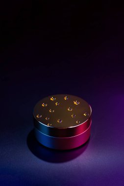 Altın bantlar ya da kavanozdaki yüz kremi. Çok renkli neon ışıkla yerleşmiş. Siyah bir arka planda. Susuzluk kavramı.