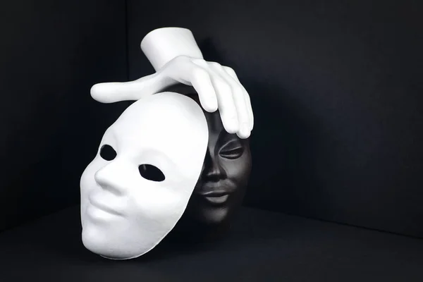 Черно-белая концепция расизма или театра. Лицо, маска и рука на темном геометрическом фоне — стоковое фото