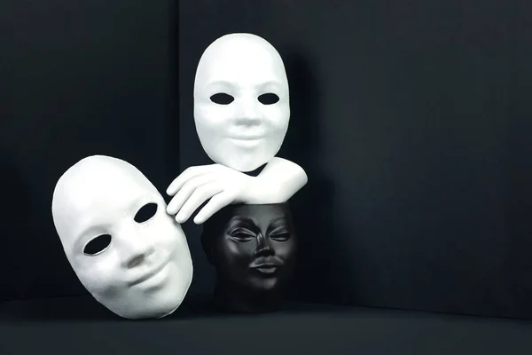 Ett svartvitt begrepp om rasism eller teater. Ansikte, mask och hand på en mörk geometrisk bakgrund — Stockfoto