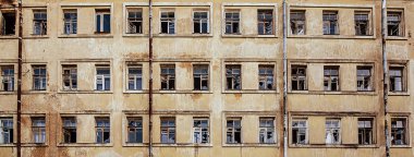 Pencereleri kırık, terk edilmiş, çok katlı bir evin manzarası. Grunge endüstriyel konsepti. Pankart