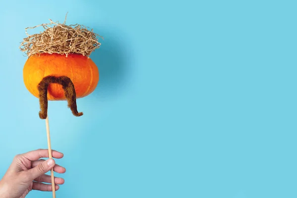 Pomerančová dýně s knírkem a sennými chlupy. Halloween koncept. — Stock fotografie
