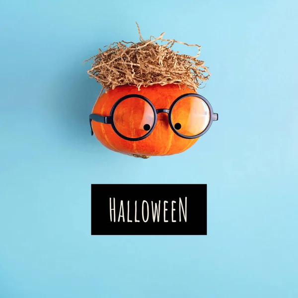 Gözlüklü turuncu balkabağı ve bir tutam saman. Cadılar Bayramı konsepti. — Stok fotoğraf