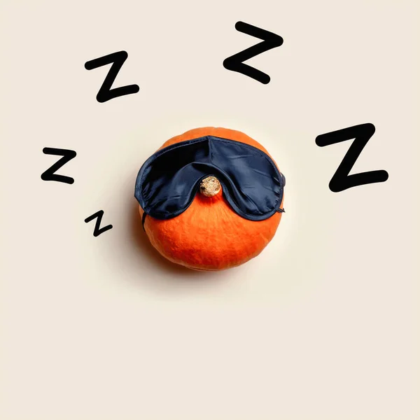 The orange pumpkin sleeps in a sleeping bandage on a light background. Halloween concept.