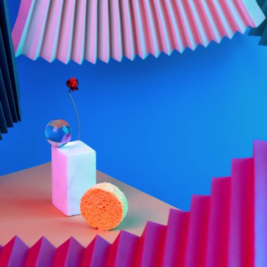 Podyumdaki geometrik şekiller piramidi, neon ışıklarıyla aydınlatılmış, yelpaze ve kağıdın arka planı ters açıyla aydınlatılmış. Kavram.