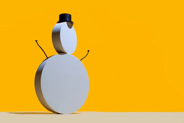 Nytår koncept, en snemand af runde hvide podier og en hat cylinder på en lys gul baggrund. - Stock-foto