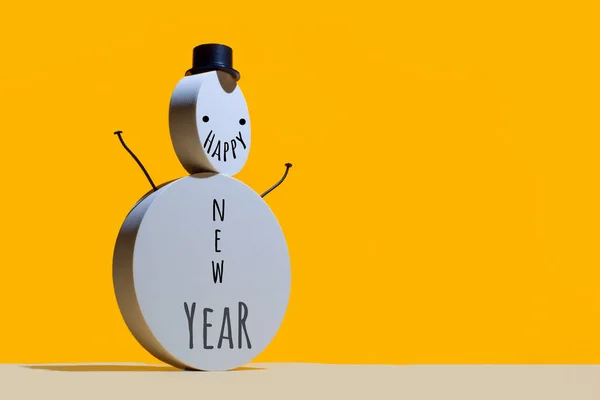 Концепция Нового года, снеговик из круглых белых поэтов и шапка-ушанка на ярко-желтом фоне. — стоковое фото