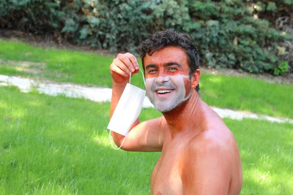 close-up portrait of young man sun tan with tan lines in shape of medical mask