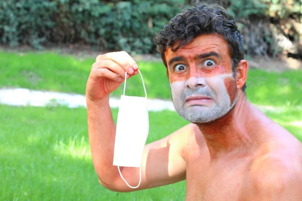 close-up portrait of young man sun tan with tan lines in shape of medical mask