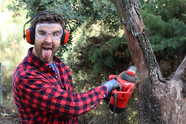 man cutting tree with chainsaw in forest