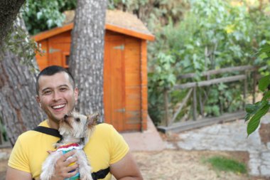 Yakışıklı bir delikanlının sokakta küçük şirin bir köpek yavrusuyla yakın plan portresi.