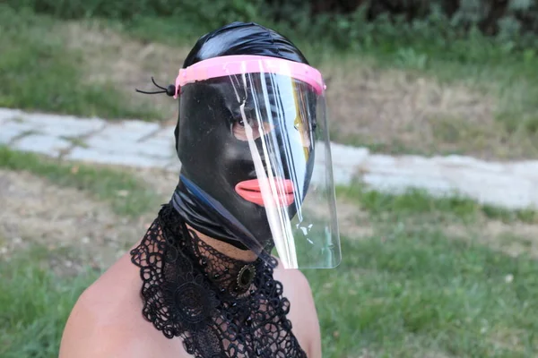 ラテックスBdsmマスクのハンサムな若い男と緑の公園のCovidシールドのクローズアップ肖像画 — ストック写真
