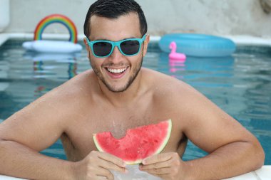 Yüzme havuzunda kameraya bakan yakışıklı genç adamın yakın plan portresi.