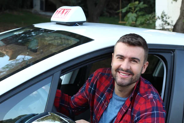 Yakışıklı genç bir taksi şoförünün arabasıyla portresi.