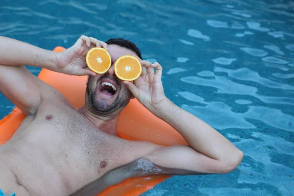 Close Retrato Belo Jovem Flutuando Colchão Inflável Segurando Metades Laranja — Fotografia de Stock