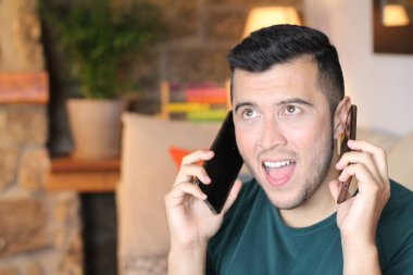 Evde telefonla konuşan yakışıklı bir gencin yakın plan portresi.