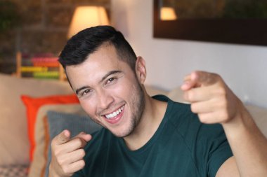 Evdeki kanepede oturan yakışıklı genç adamın yakın plan portresi.