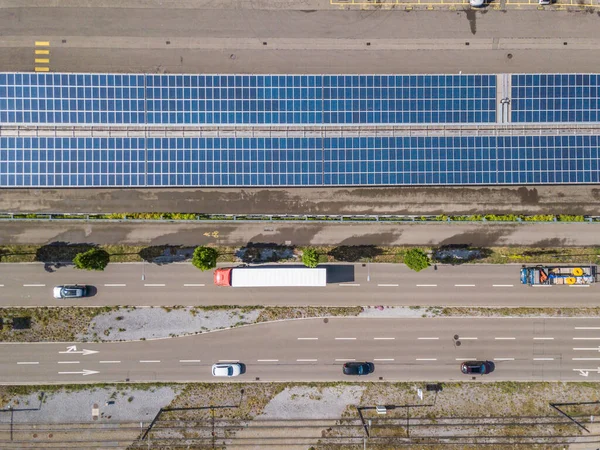 İnşaat ve yoldaki çatı güneş panelinin havadan görüntüsü. Şehir trafiği. Sürdürülebilirlik kavramı.