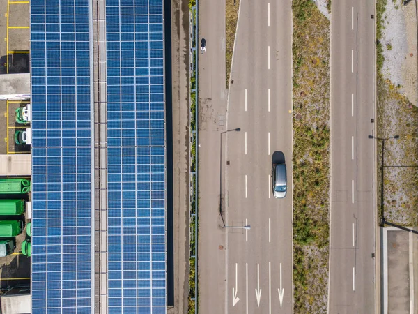 İnşaat ve yoldaki çatı güneş panelinin havadan görüntüsü. Şehir trafiği. Sürdürülebilirlik kavramı.