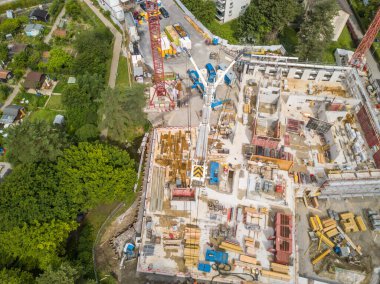 İsviçre 'nin yerleşim alanındaki büyük vinçli inşaat alanının havadan görüntüsü.