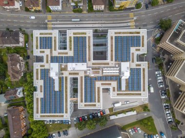 Fotovoltaik güç üretimi için güneş pilleri olan çatıların havadan görüntüsü. Gelecekteki şehirler için yeşil enerji kavramı.