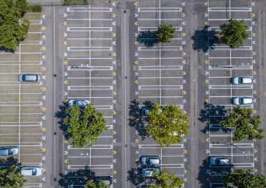 Güneşli yaz gününde neredeyse boş olan büyük araba parkının havadan görüntüsü..