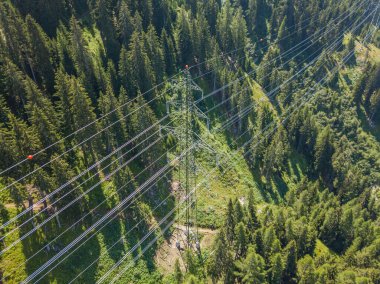 İsviçre 'deki Alp Ormanı' ndan geçen elektrik hattının havadan görüntüsü. Elektrik şebekesi ile elektrik dağıtımı.