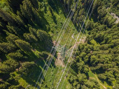 İsviçre 'deki Alp Ormanı' ndan geçen elektrik hattının havadan görüntüsü. Elektrik şebekesi ile elektrik dağıtımı.