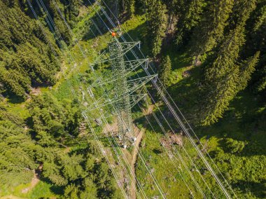 İsviçre 'deki Alp Ormanı' ndan geçen elektrik hattının havadan görüntüsü. Elektrik şebekesi ile elektrik dağıtımı.