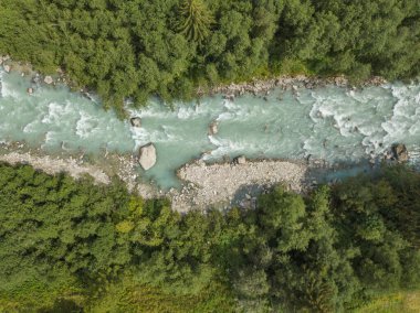 İsviçre Alplerindeki nehirdeki beyaz su akıntılarının hava görüntüsü. Doğanın vahşi suları..