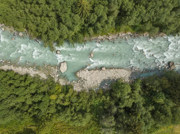 İsviçre Alplerindeki nehirdeki beyaz su akıntılarının hava görüntüsü. Doğanın vahşi suları..